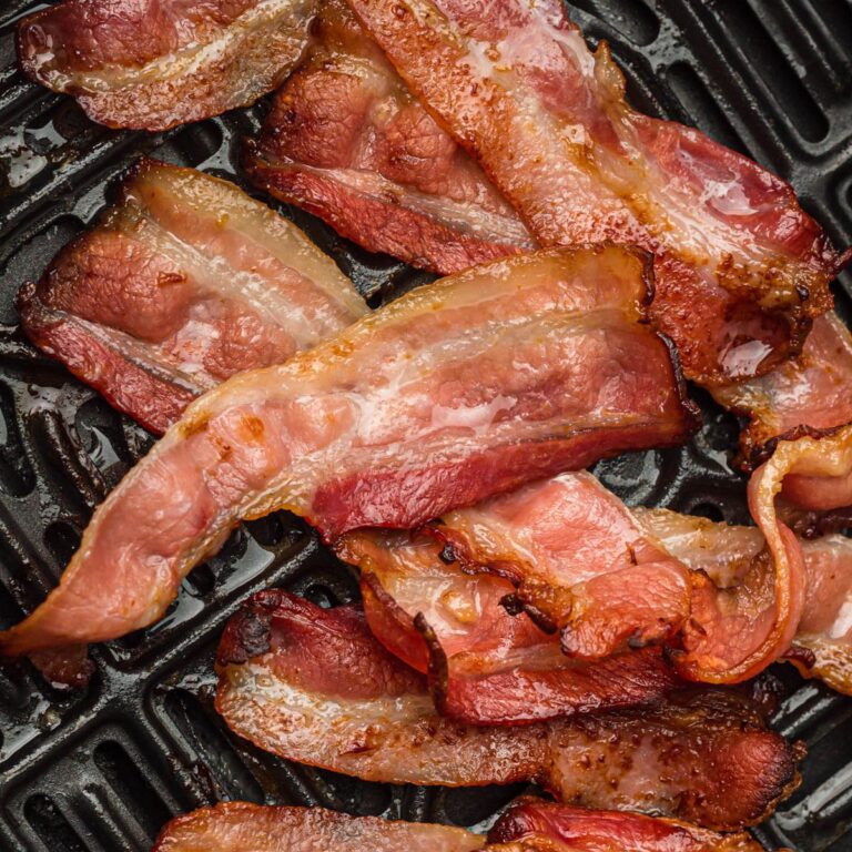 Bacon in the basket of an air fryer.
