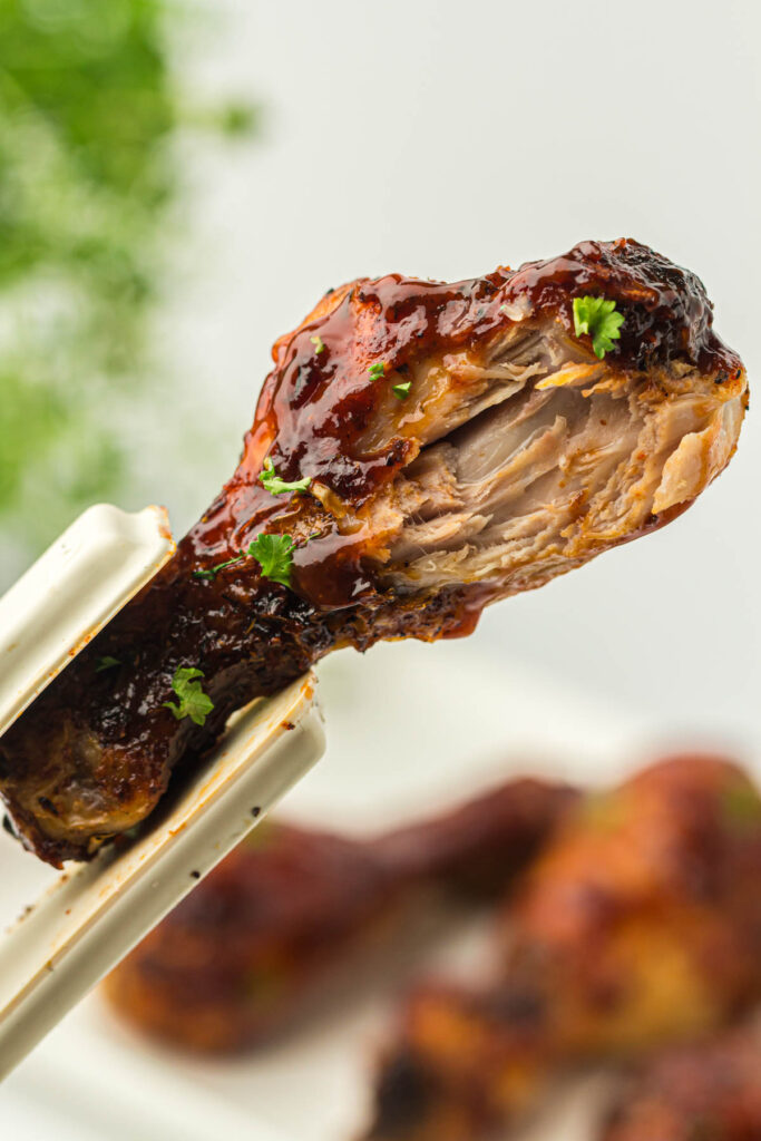 Chicken leg with a bite taken out of it.