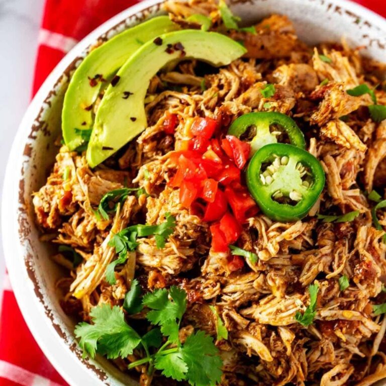 Chicken Tinga in a bowl with avocado and cilantro.