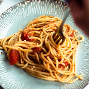 A fork twirling spaghetti with red sauce.