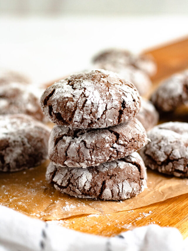 Stack of 3 crack cookies coated in powdered sugar to reveal the cracks that bake into them.