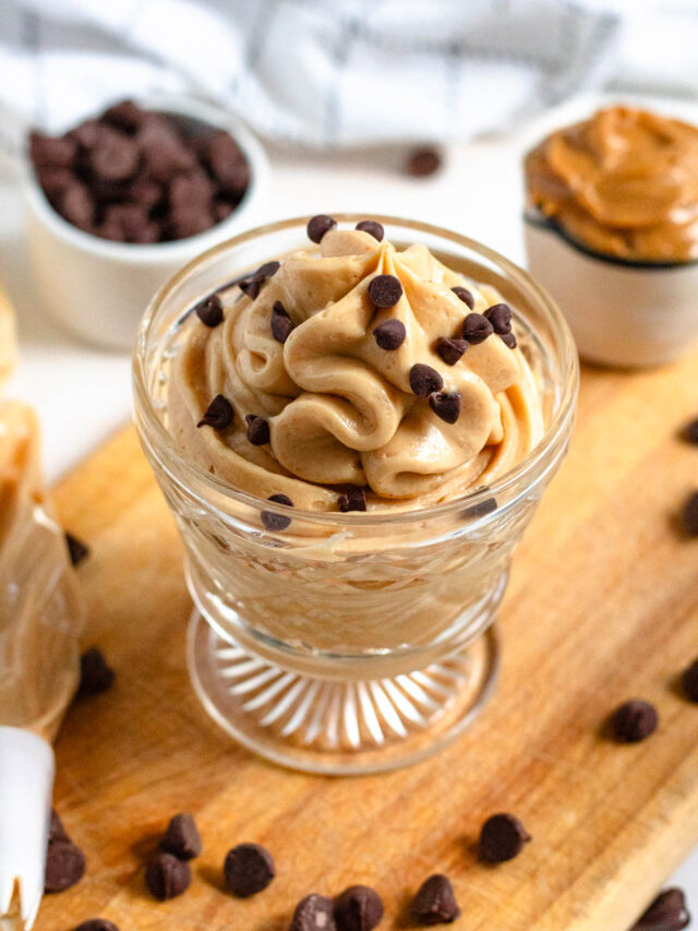 Peanut butter mousse in a glass with chocolate chips garnished on top.