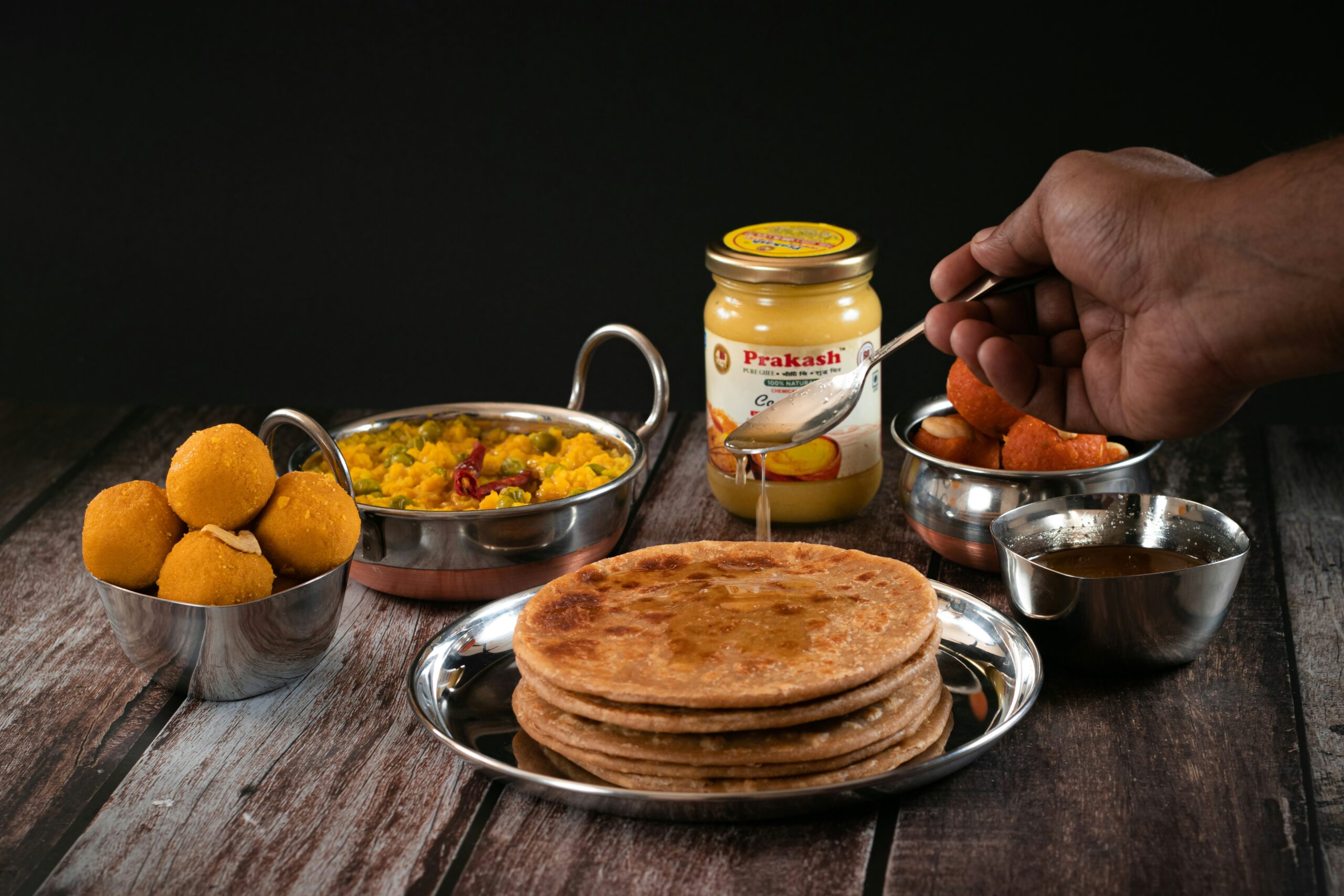a hand scooping ghee